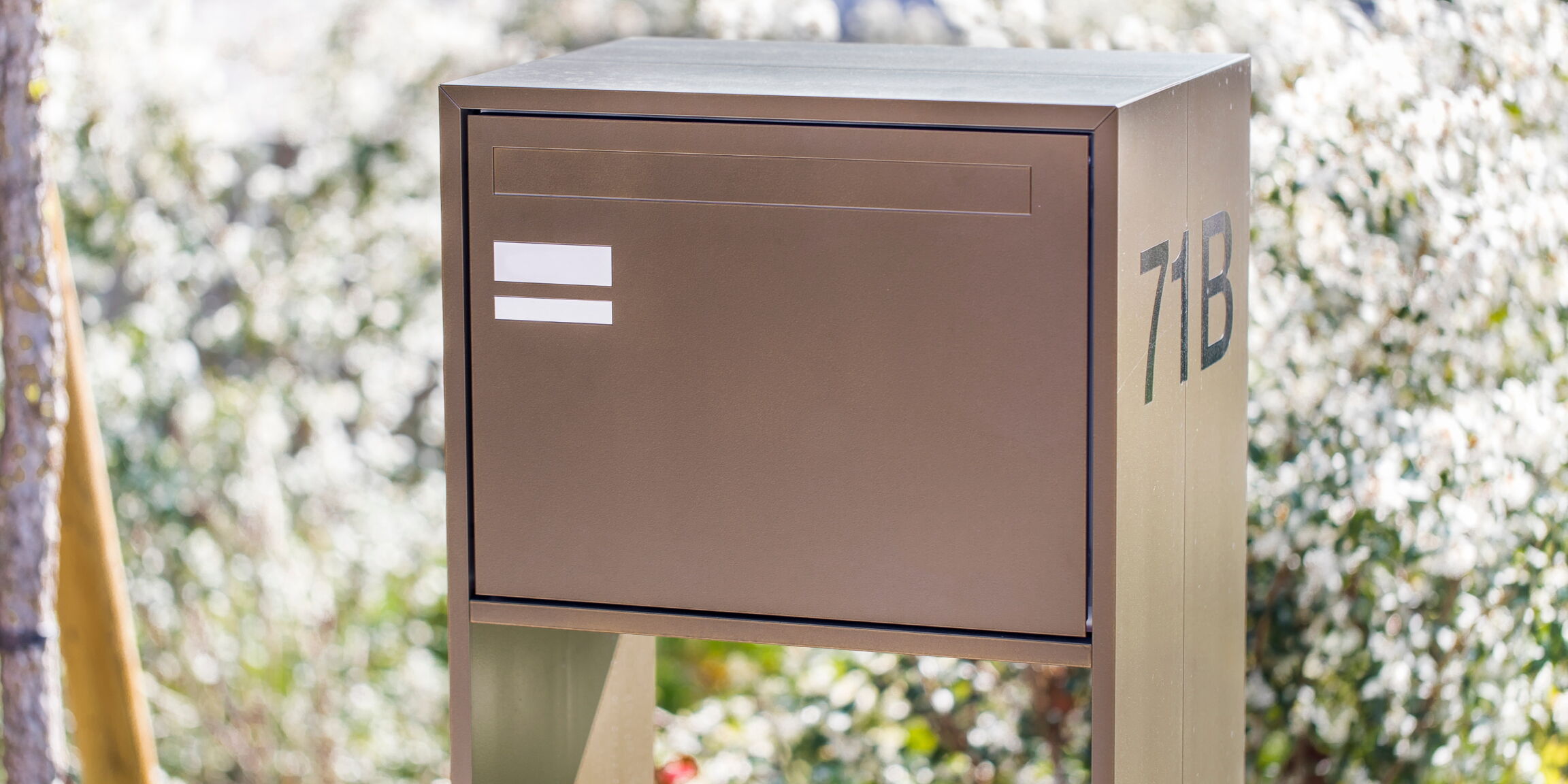 Einfamilienhaus-Briefkasten in Braun mit Hausnummer seitlich an Stütze